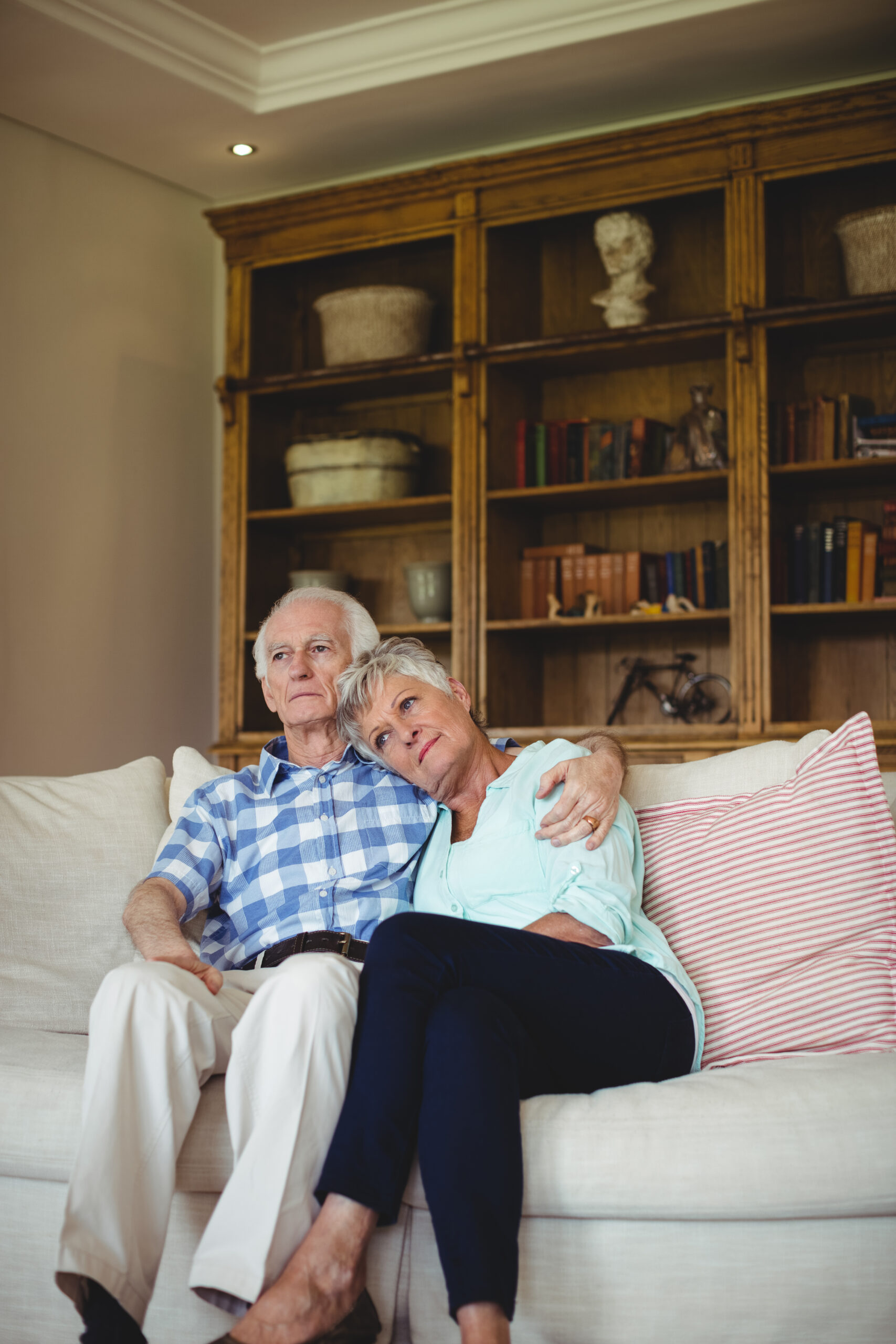 An older couple walking arm in arm outside a senior living community